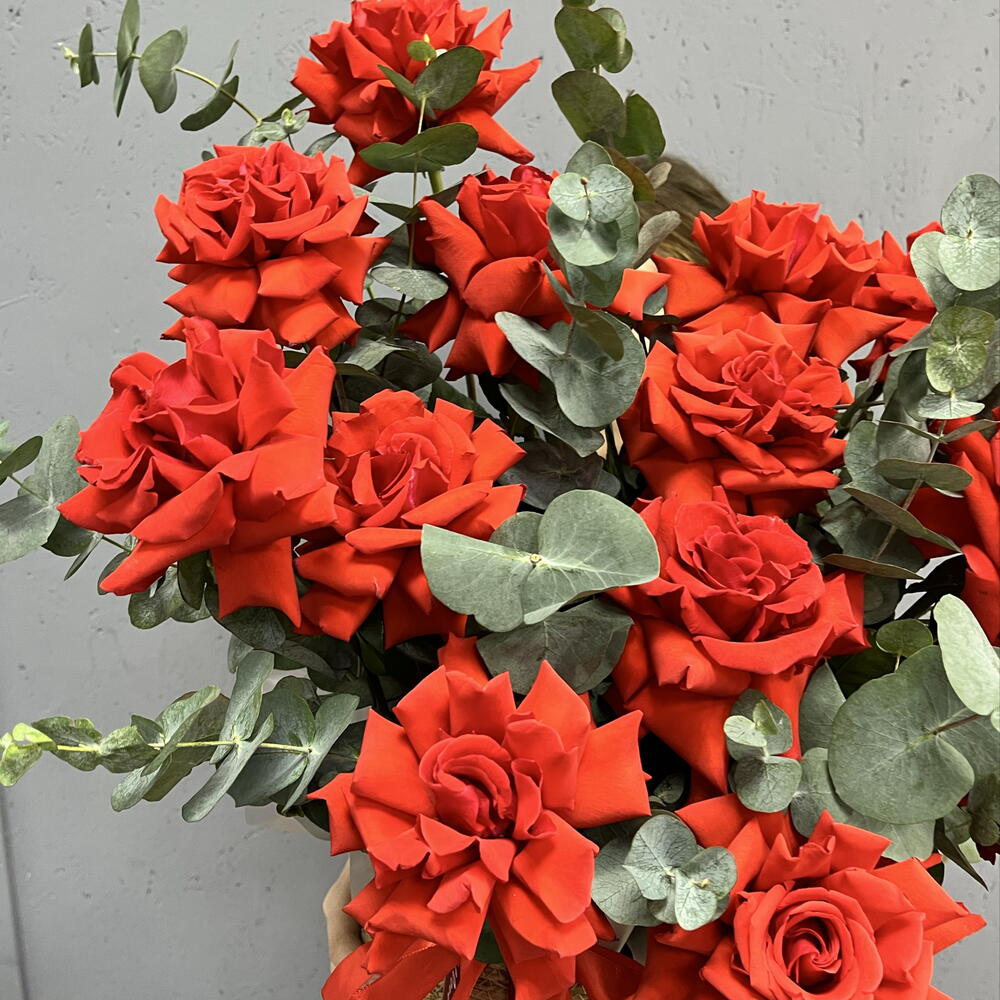 Композиция из 15 французских алых роз с эвкалиптом в плетёной корзине «Страсть в деталях»
