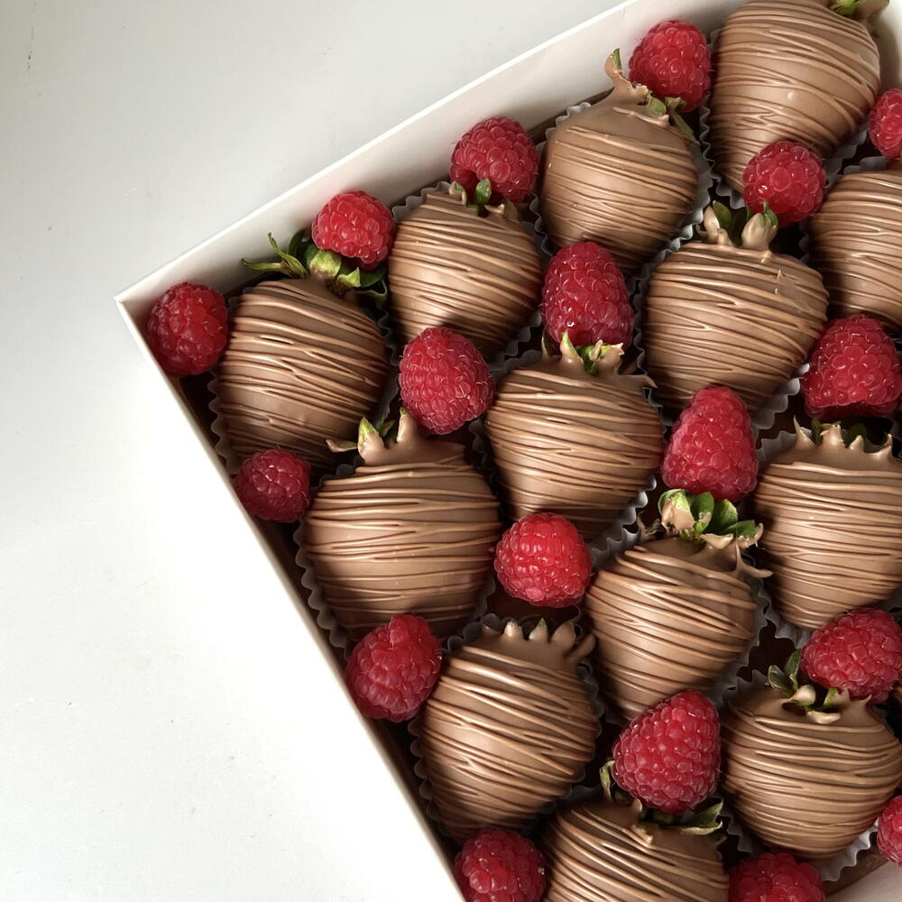 Strawberries in milk chocolate with fresh raspberries