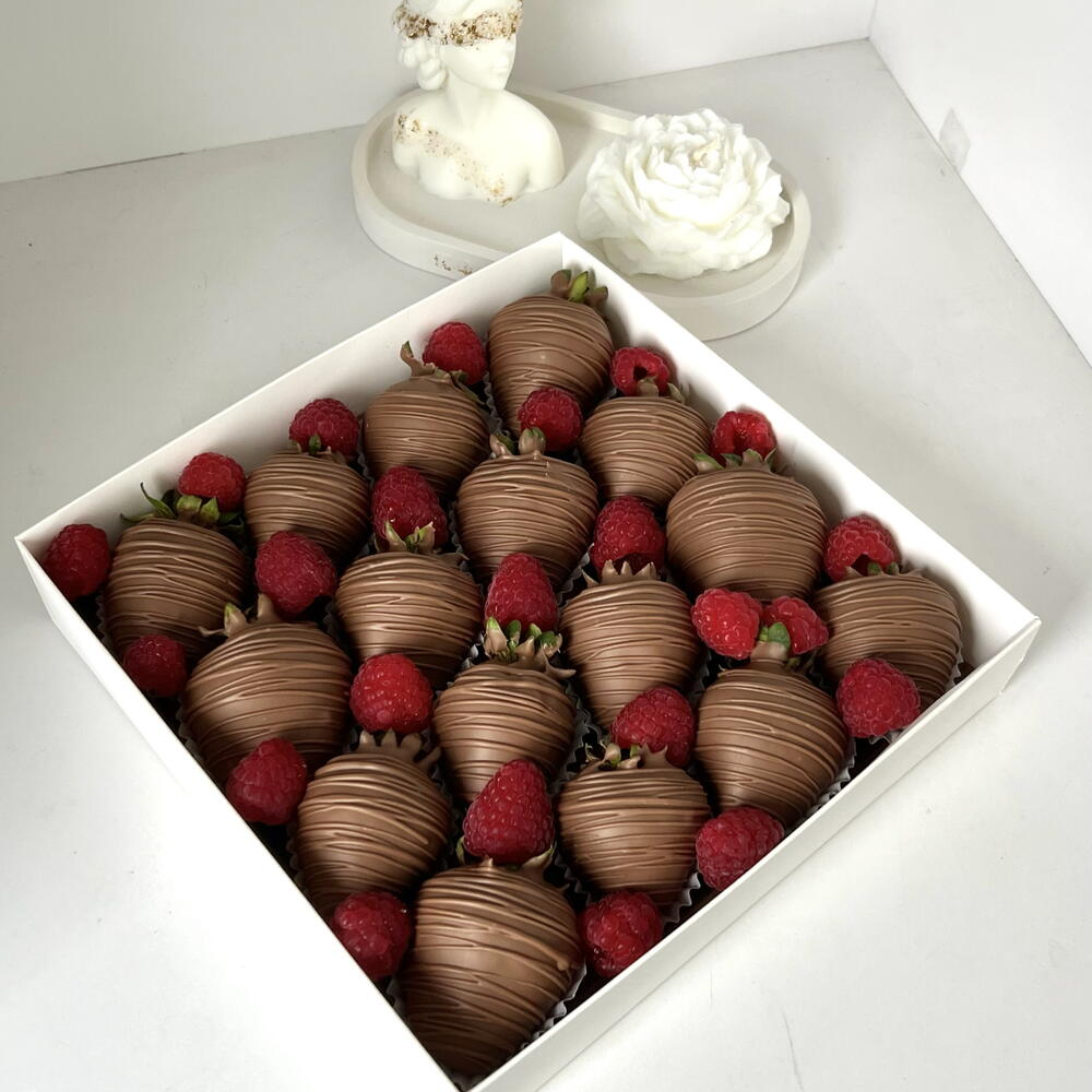 Strawberries in milk chocolate with fresh raspberries
