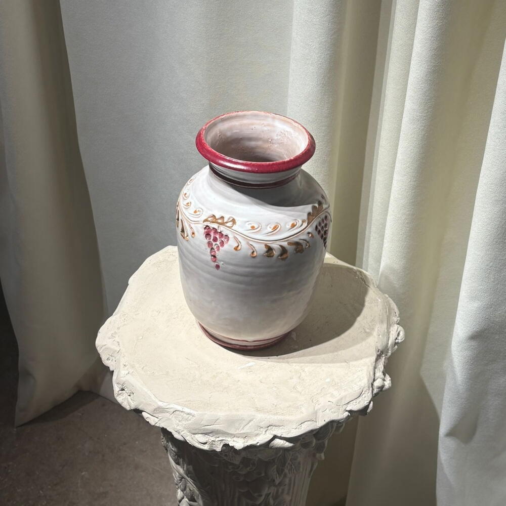 A vase with a red cranberry pattern.
