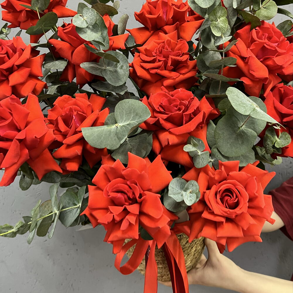Композиция из 15 французских алых роз с эвкалиптом в плетёной корзине «Страсть в деталях»