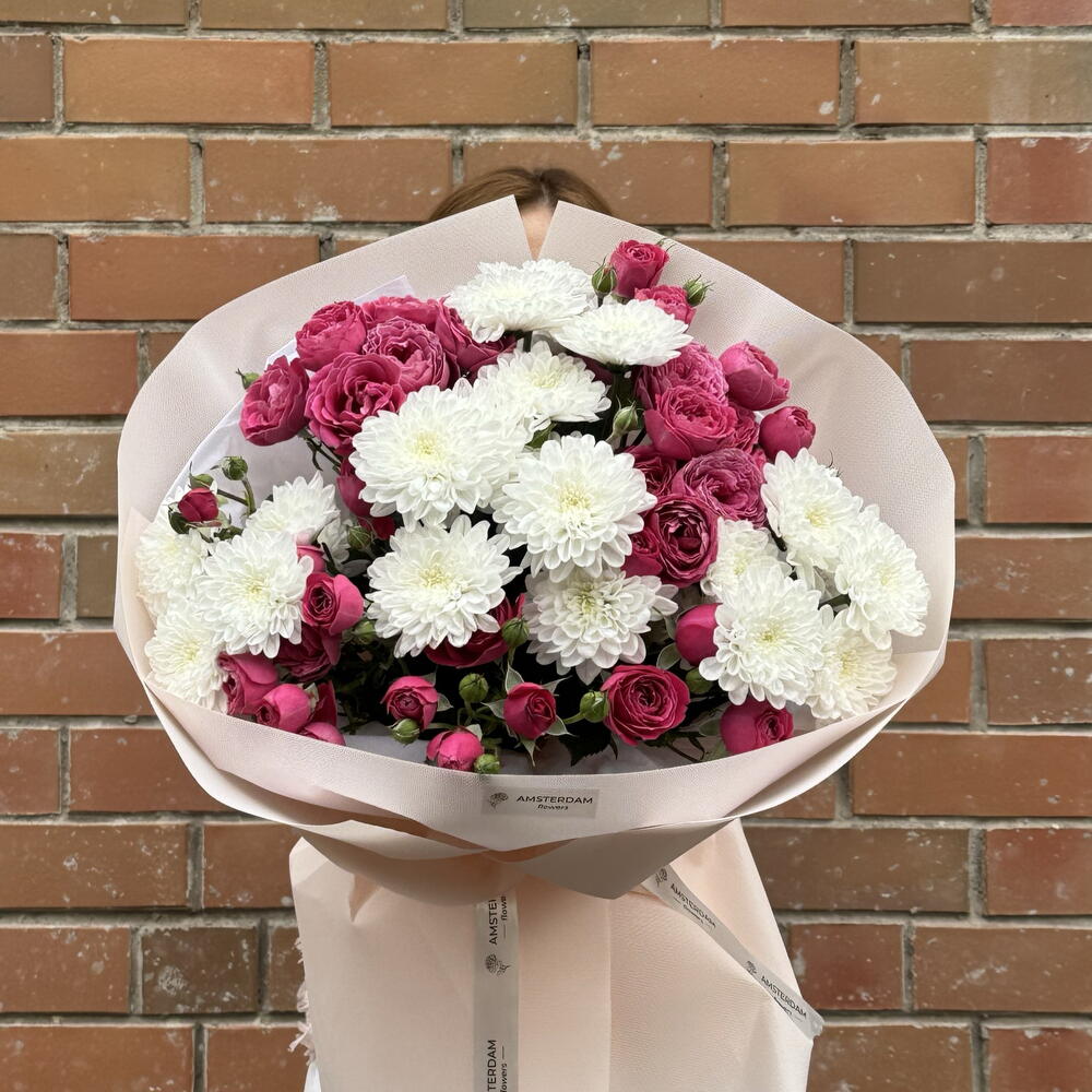 A bright bouquet featuring spray roses and a chrysanthemum.