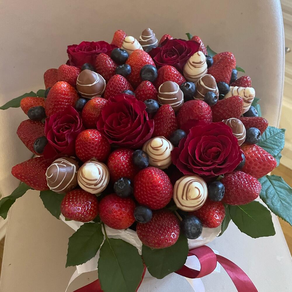 Fresas, arándanos con rosas en una Caja
