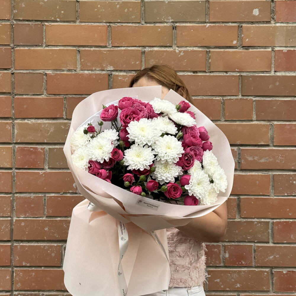 A bright bouquet featuring spray roses and a chrysanthemum.