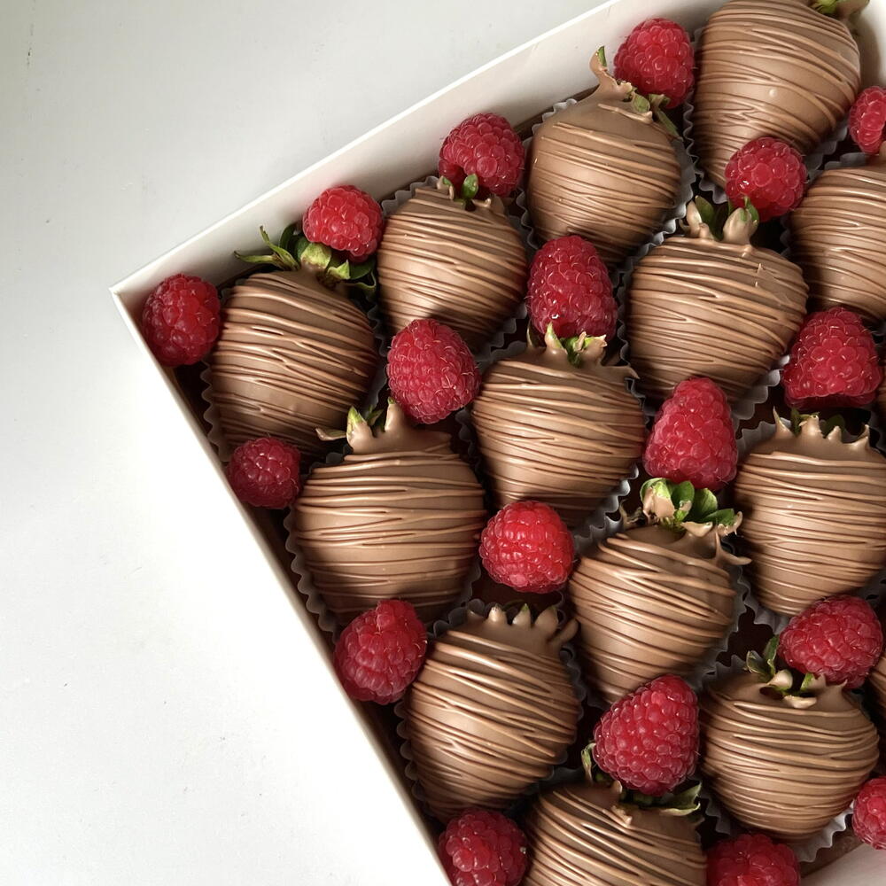 Strawberries in milk chocolate with fresh raspberries
