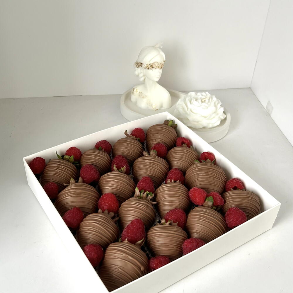 Strawberries in milk chocolate with fresh raspberries