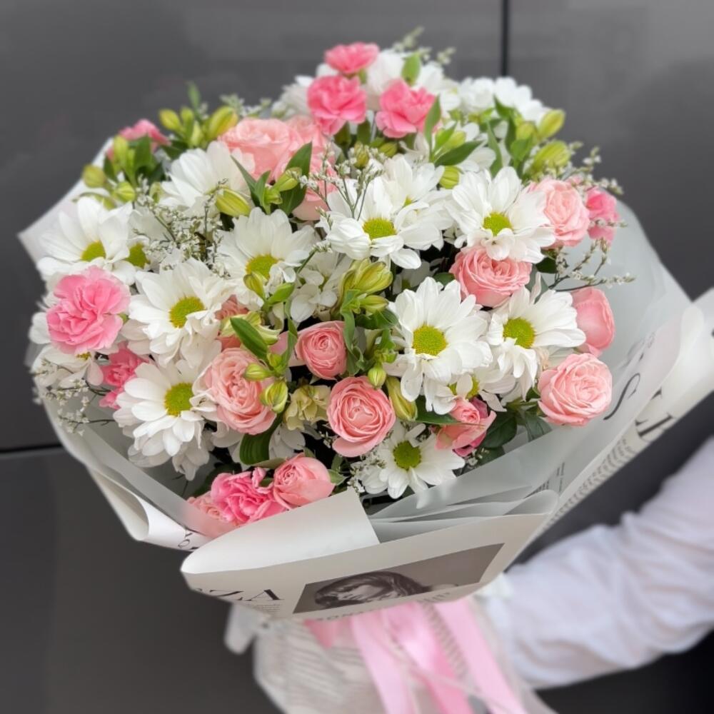 A persistent, voluminous bouquet of daisies and bush roses