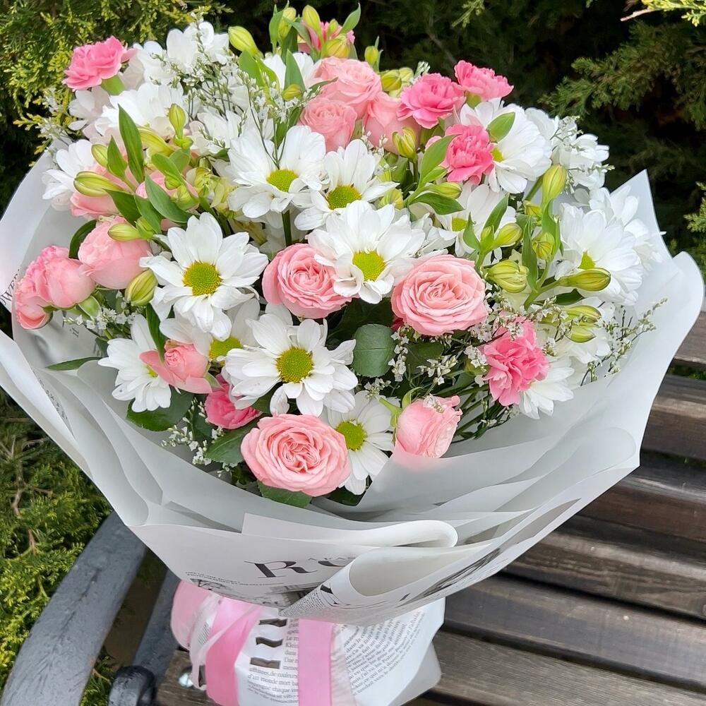 A persistent, voluminous bouquet of daisies and bush roses