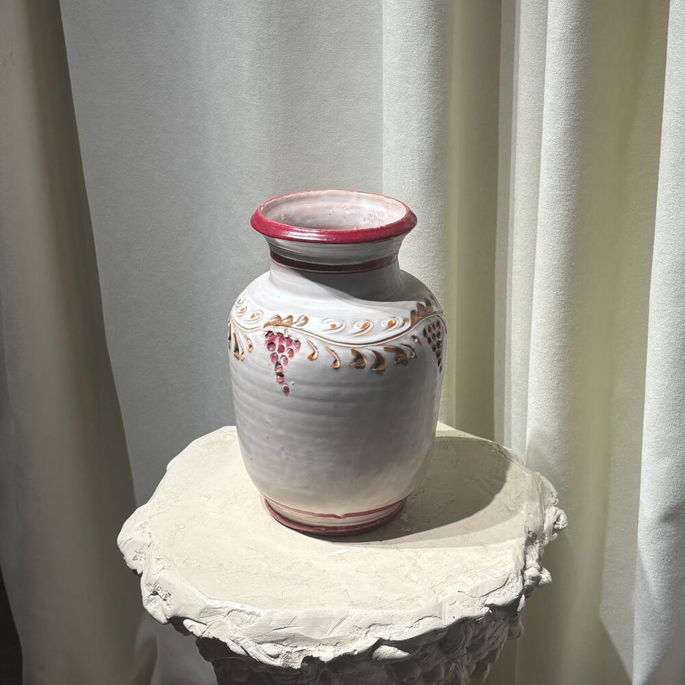 A vase with a red cranberry pattern.