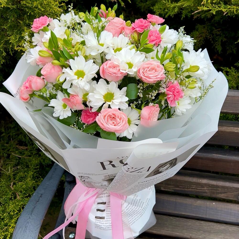 A persistent, voluminous bouquet of daisies and bush roses