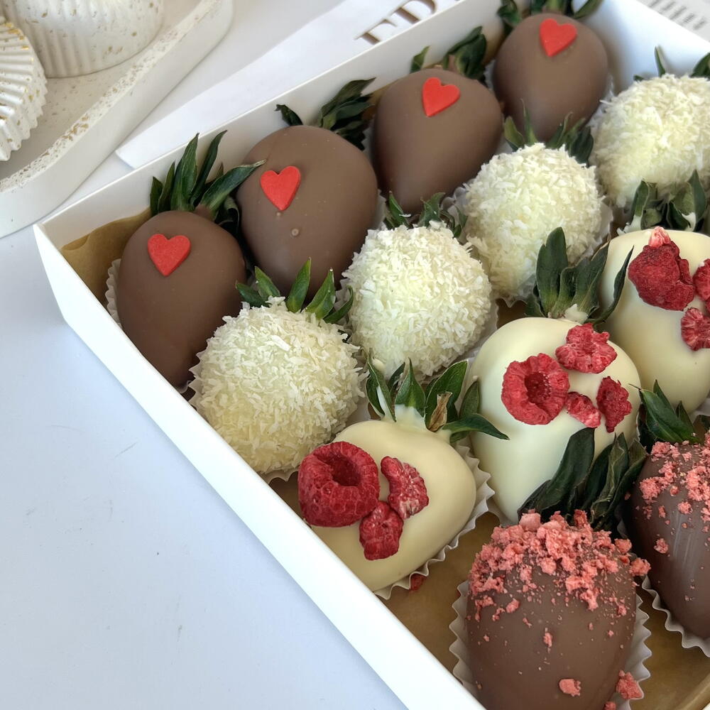 Strawberries in white and milk chocolate with freeze-dried raspberries and strawberries