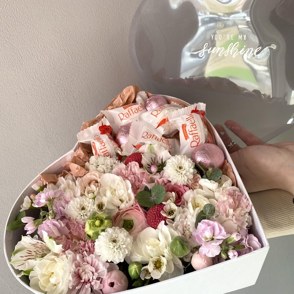 Цветы в коробке в форме сердца с конфетами Raffaello