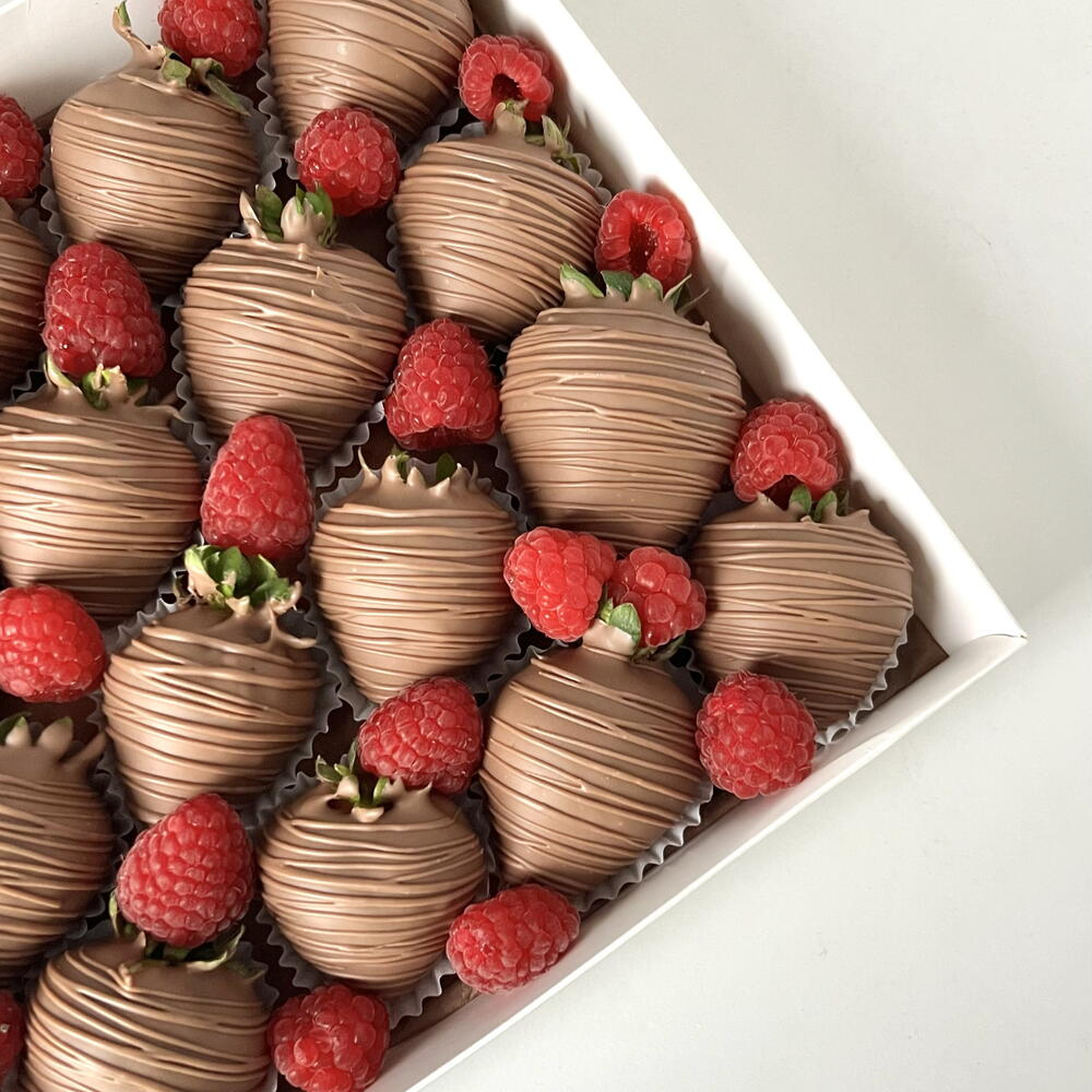 Strawberries in milk chocolate with fresh raspberries