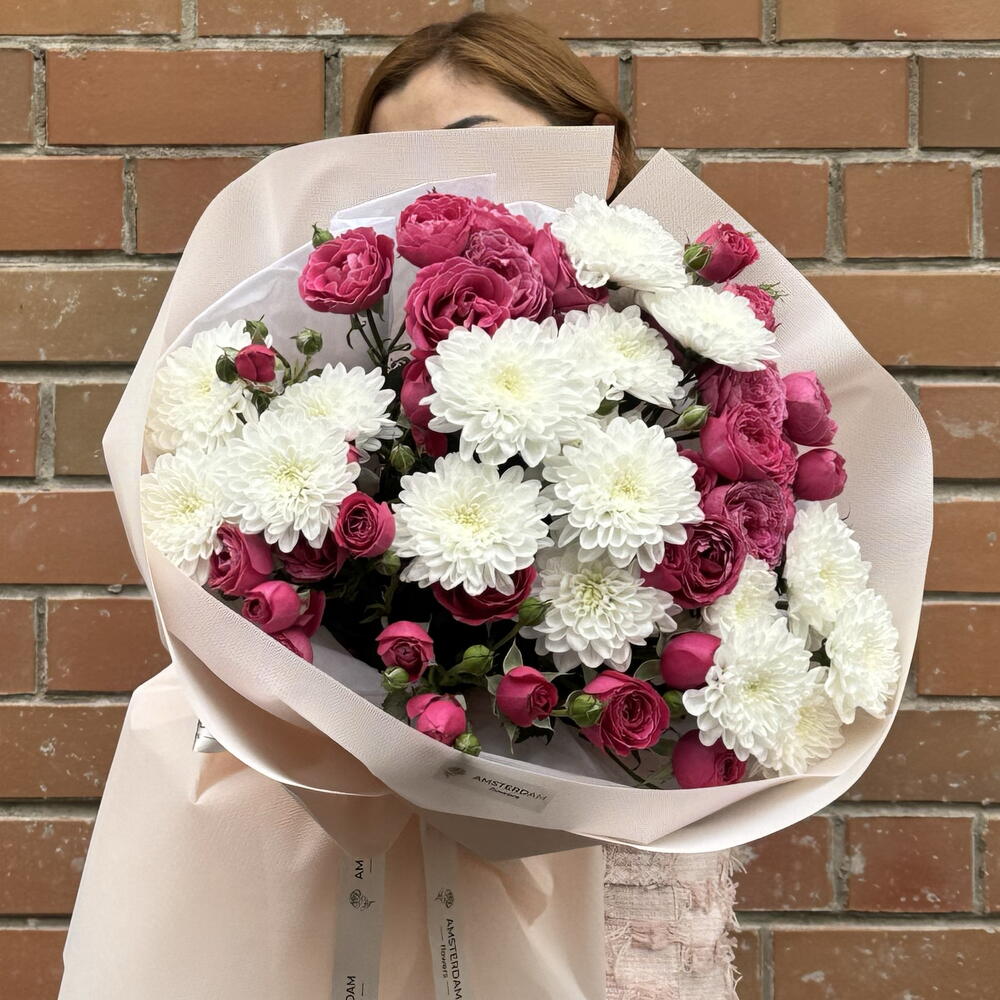 A bright bouquet featuring spray roses and a chrysanthemum.