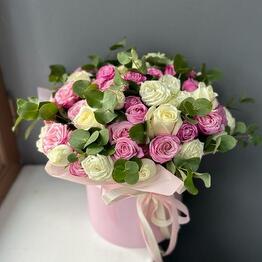 Peony-shaped bush roses in a hatbox with eucalyptus
