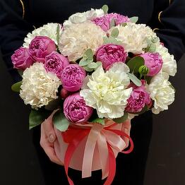 A composition in a box with peony-shaped roses and dianthus
