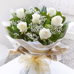 7 white roses with greenery