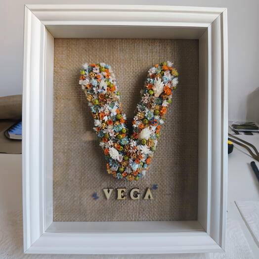 Marco con inicial hecha con flor preservada y seca