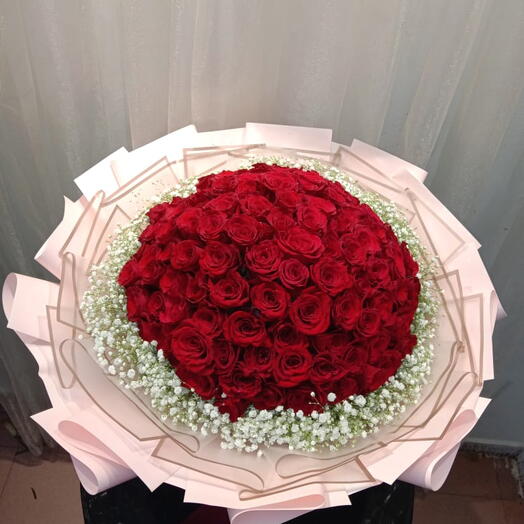 50 Stems of Red roses with baby breath in a round shape nicely wrraping