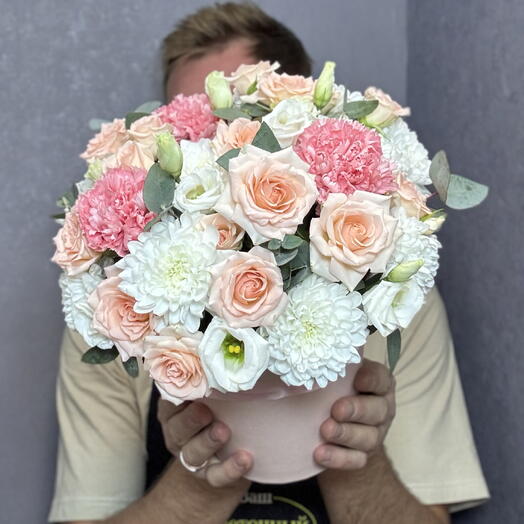 A box of bush roses, pink dianthuses and bush chrysanthemums
