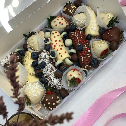 Fresas, plátanos y arándanos cubiertos de chocolate como regalo