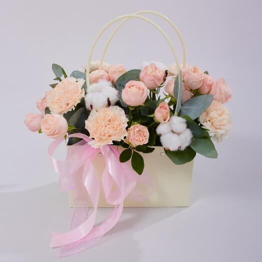 Winter composition in a handbag made of bush peony roses and eucalyptus