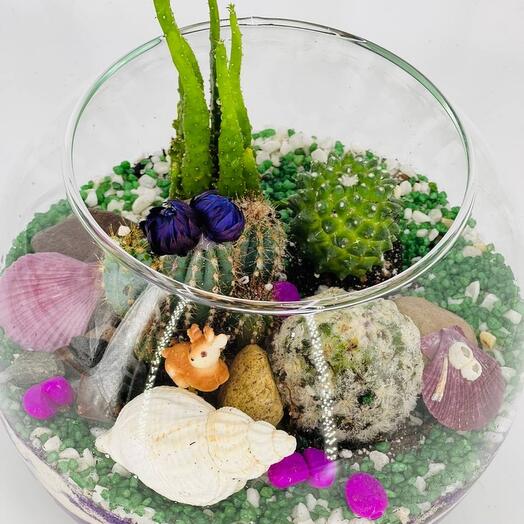 A round terrarium with cacti and a Bambi deer figurine