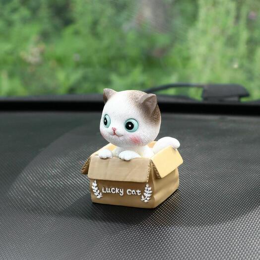 Счастливый кот на панель авто, качающий головой