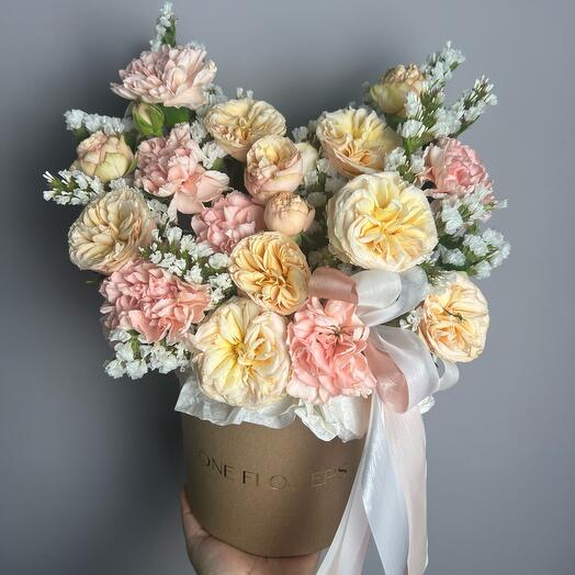 Peony-shaped bush rose, dianthuses and statice in a hatbox