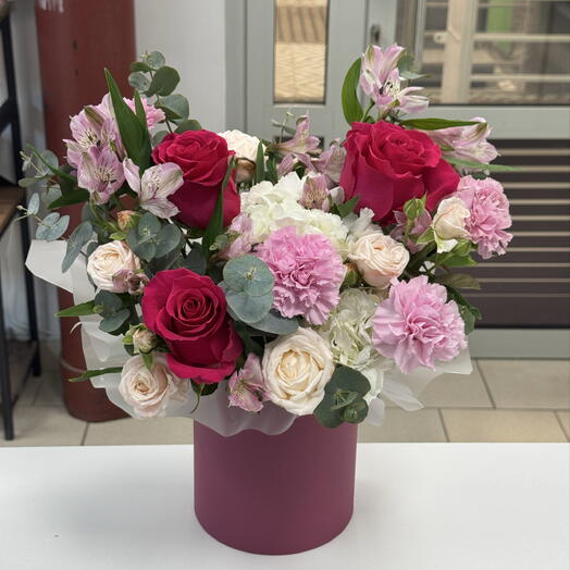 Раскидистая композиция в шляпной коробке с розами и диантусом