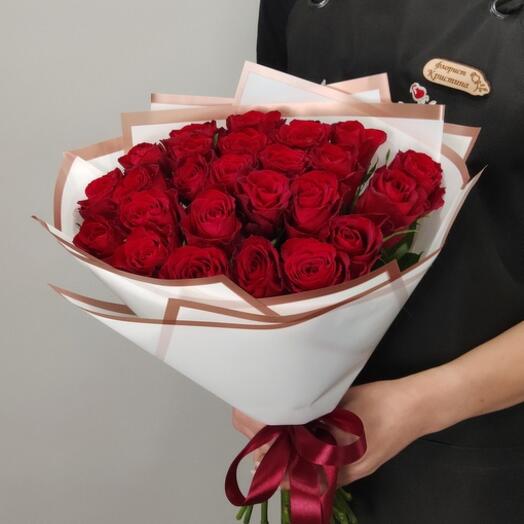 A bouquet of red roses with greens