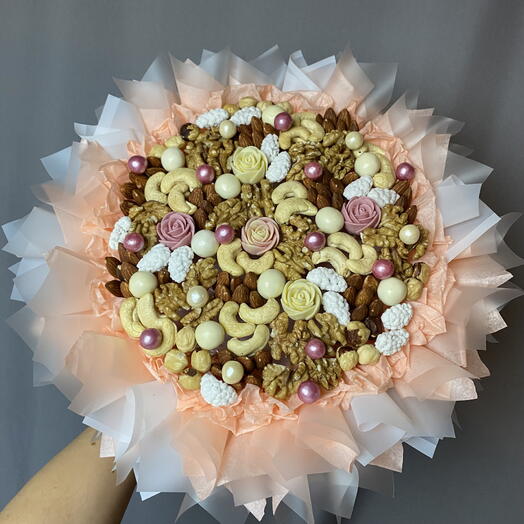 Букет с орехами и шоколадными розочками в персиковой пышной упаковке
