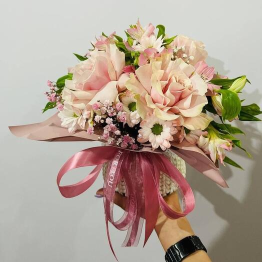 Bouquet of flowers with French roses and daisies in a knitted planter