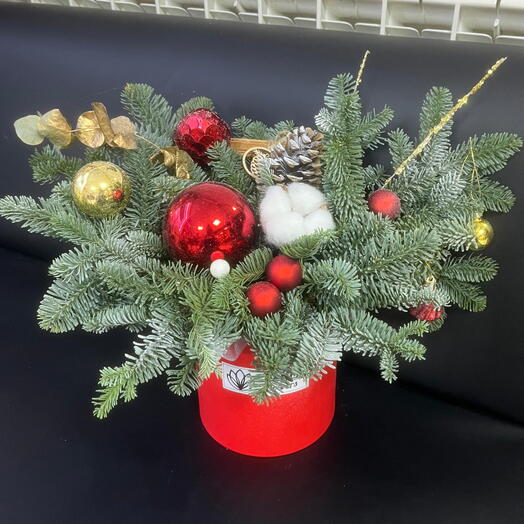 Композиция из нобилиса и красных игрушек с белым хлопком