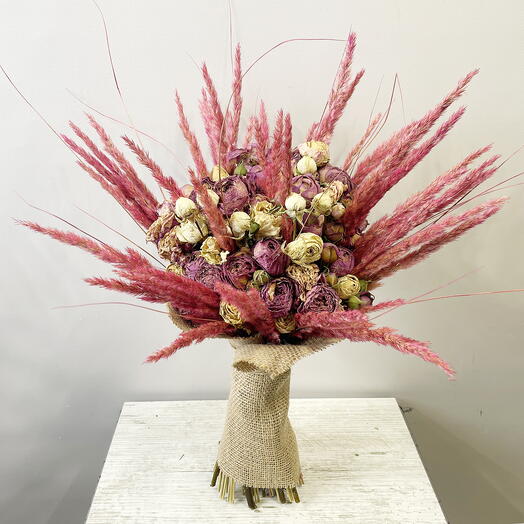 A dried bouquet of small bush roses with spikelets