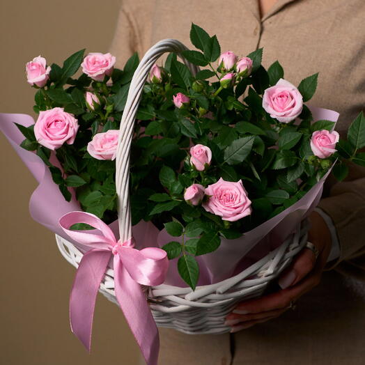 Composición de rosas vivas en una cesta de mimbre