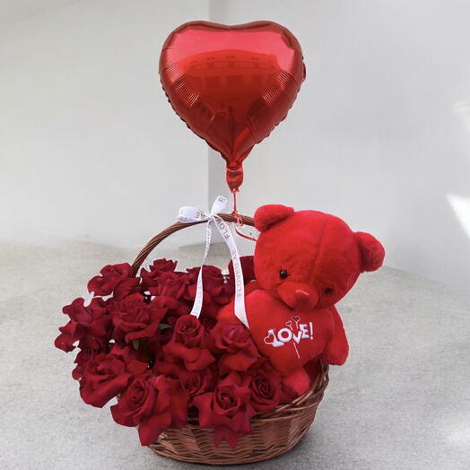 Red roses in basket with teddy bear and balloo