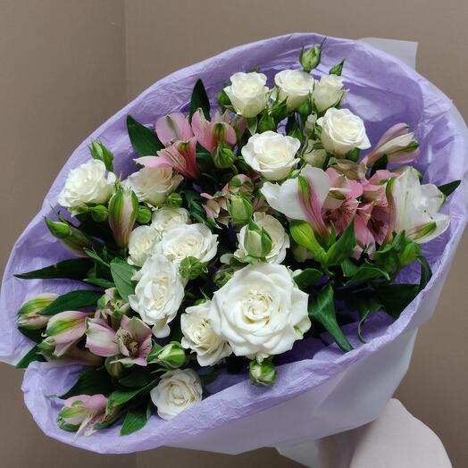 A very delicate, voluminous bouquet of snow-white bush roses and alstroemeria in a round package