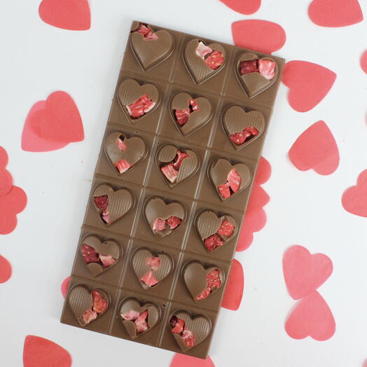 Chocolate con leche en forma de corazón con fresas liofilizadas