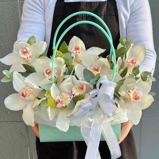 White orchids with eucalyptus in a handbag