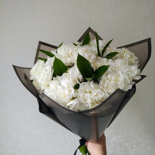White carnations with greens. Fresh flowers in the cemetery. Funeral bouquet of carnations. Cloves and greens