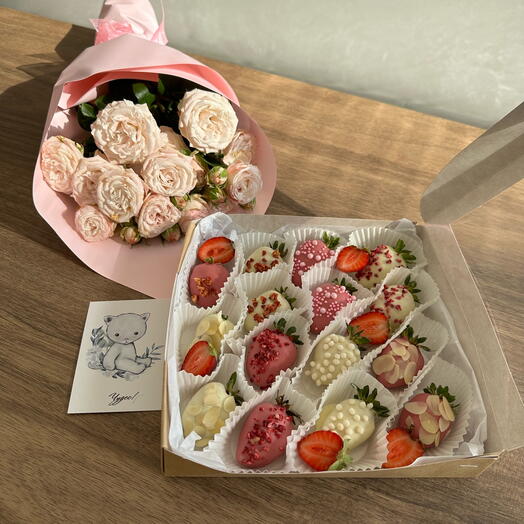 Set di fragole ricoperte di cioccolato e bouquet di fiori