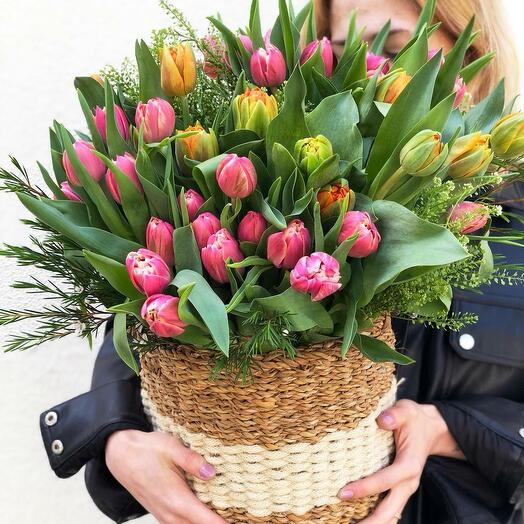 Bouquet of assorted peony tulips and greenery in a basket