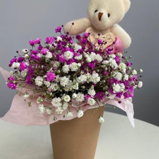 Composición de gypsophila de color con un oso pequeño