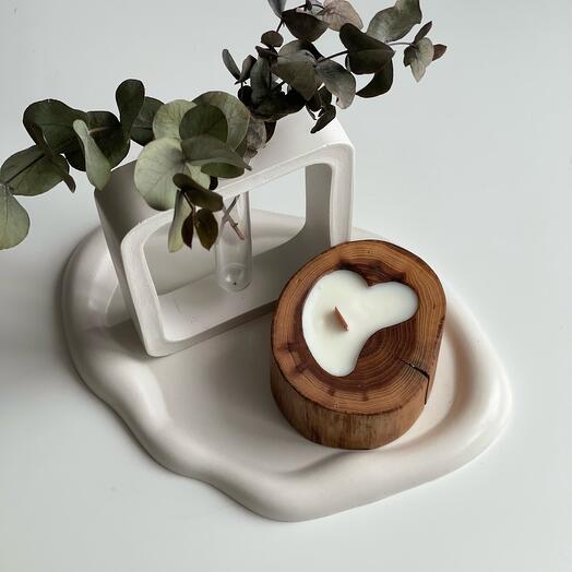 An aromatic candle on a plaster tray with a vase . Gift set for home and comfort