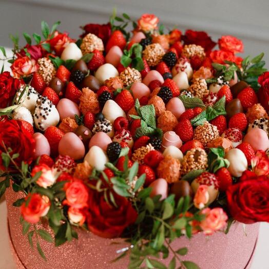 Strawberries, berries and flowers in a box