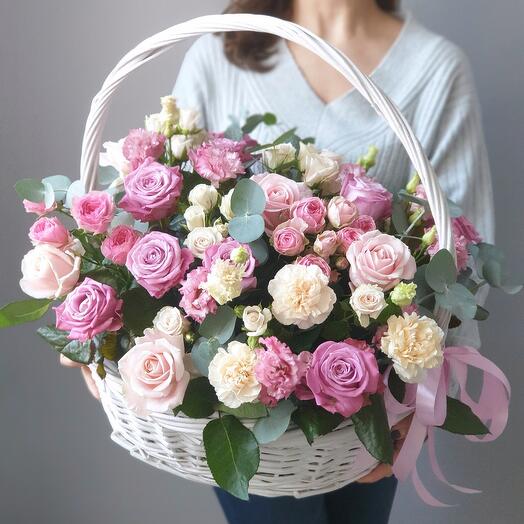 Basket with delicate lilac roses, fragrant dianthus and lisianthus