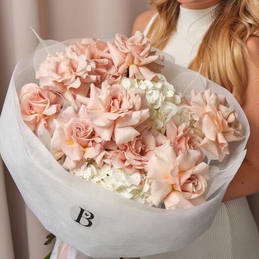 A large stylish bouquet of French roses and snow-white hydrangeas with glass leaves