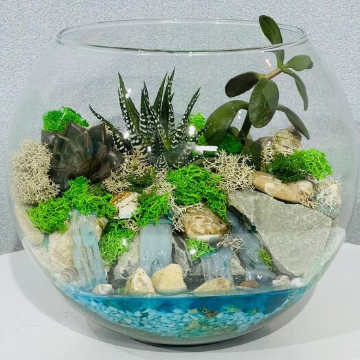 Mini garden with fresh flowers with waterfall in aquarium