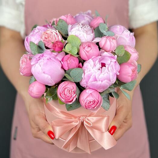 Bouquet of pink Peonies and bush Roses in a hatbox